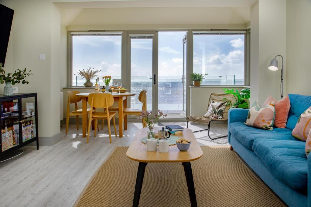 a living room with a blue couch and a table at The View in Sidmouth