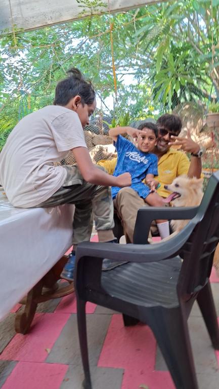 a group of people sitting on a bed with a dog at APKA ECOvillage in Trichūr