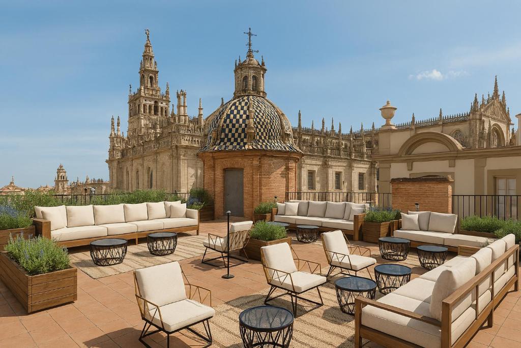 a patio with couches and chairs in front of a building at Serras Sevilla in Seville