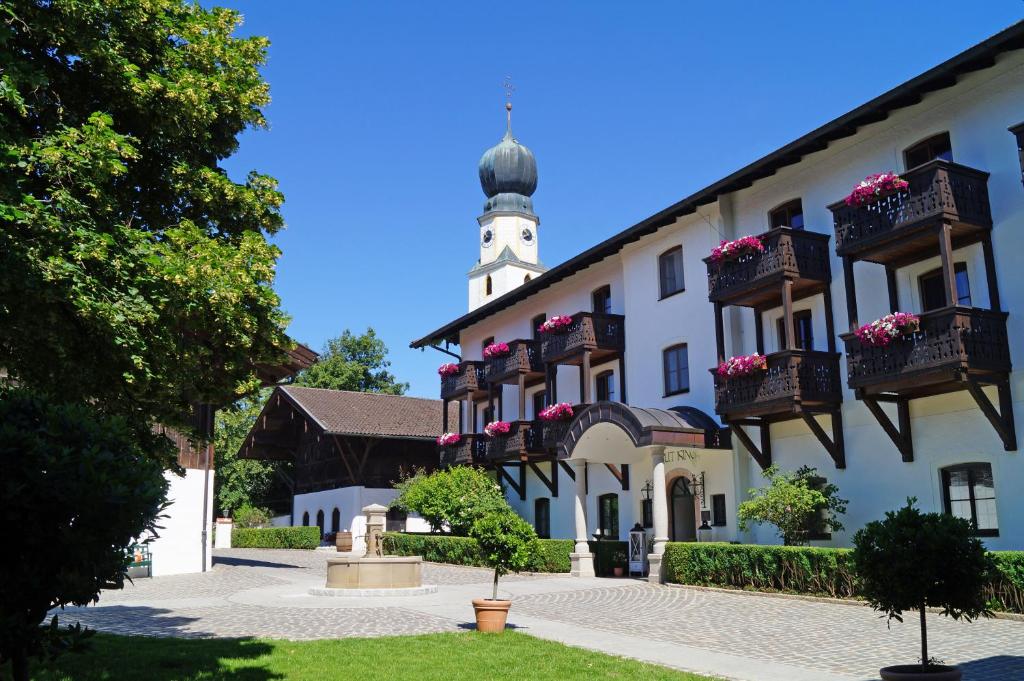 ein Gebäude mit einem Uhrturm darüber in der Unterkunft Hotel Gut Ising in Chieming