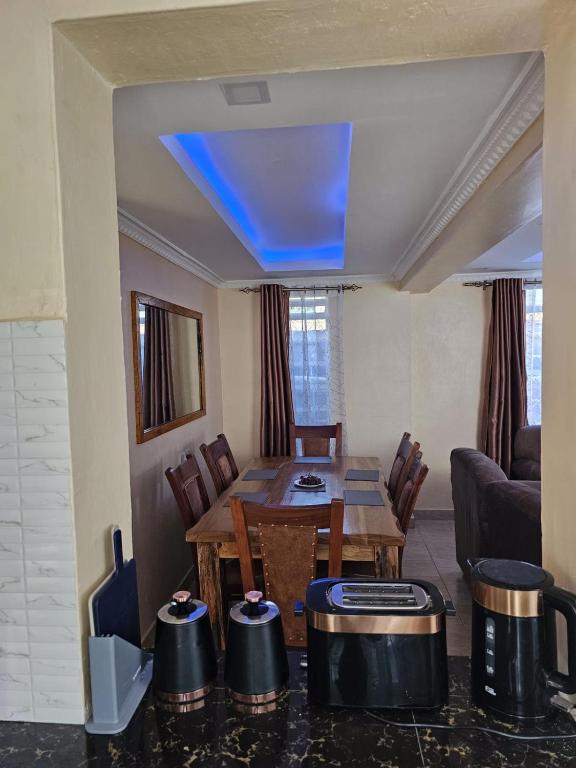 ein Wohnzimmer mit einem Tisch und einer blauen Decke in der Unterkunft Zeph Bnb in Nairobi