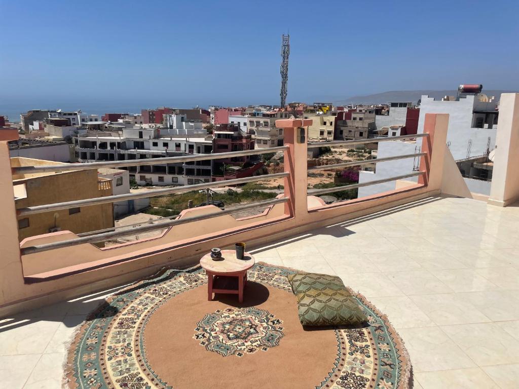 a balcony with a table and a view of a city at Mavi Surf Stay Tamraght in Tamraght Ouzdar