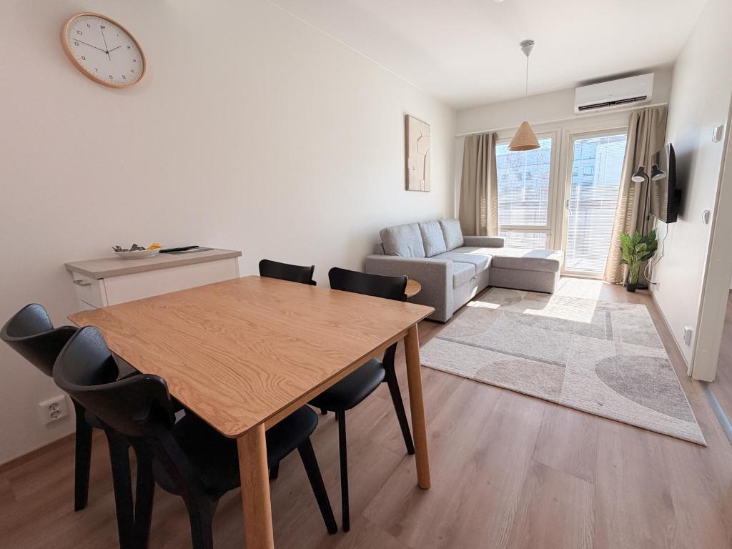 a living room with a wooden table and chairs at Lumi Glow Apartments in Rovaniemi