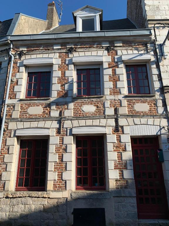 an old brick building with red windows on it at Charmants Appartements au coeur d'Arras in Arras