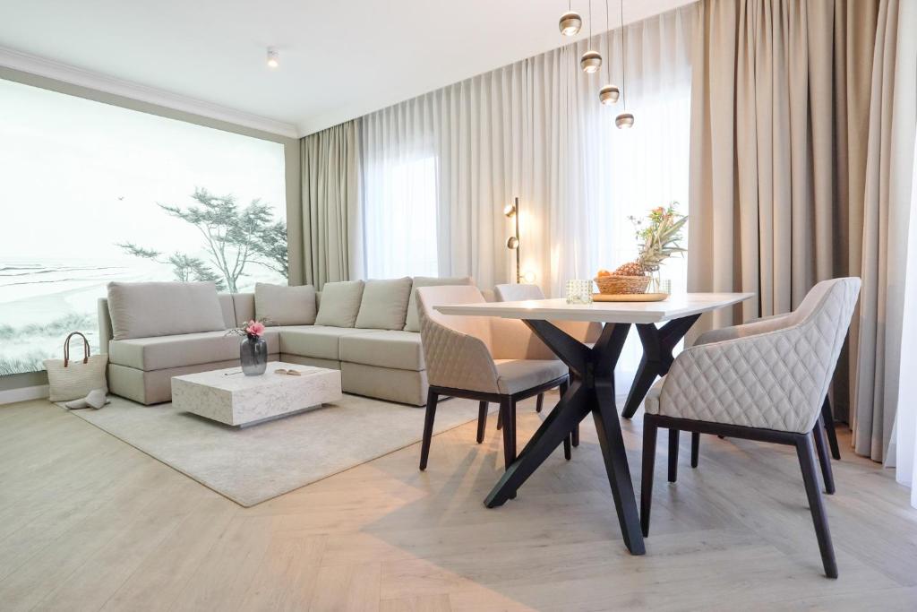 a living room with a table and a couch at Yachthafen Barth - Ferienwohnung und Penthouses in Barth