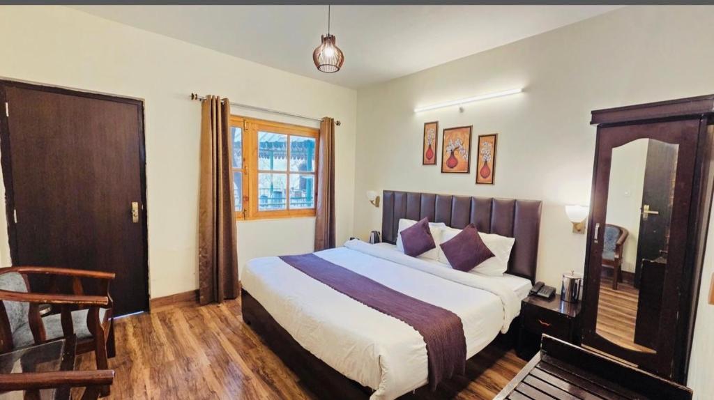 a bedroom with a large bed and a mirror at The Boho Heritage Woods in Nainital