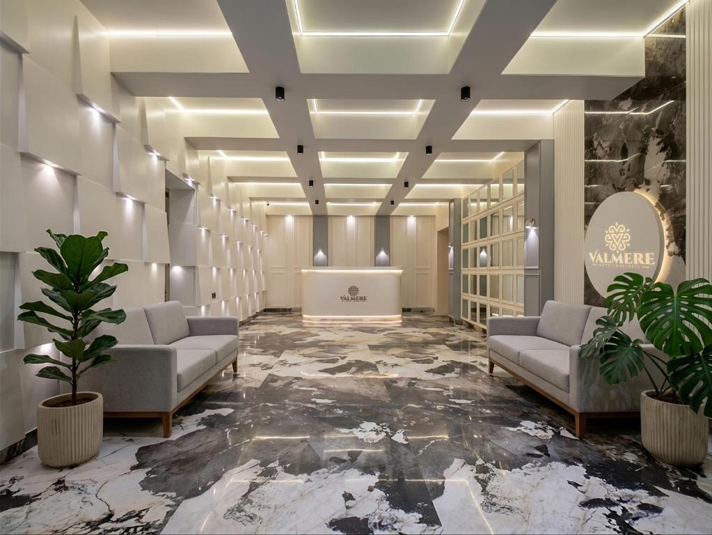 a lobby with couches and plants in a building at Valmere Chery Blossom Suites in Shillong