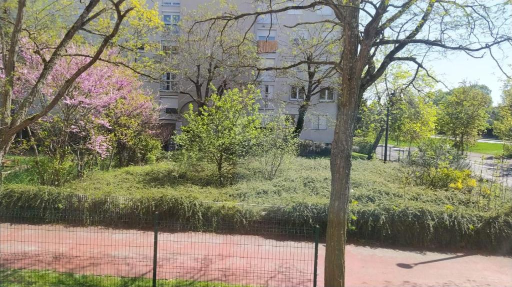 a park with a fence in front of a building at Private Quiet Place in Dijon