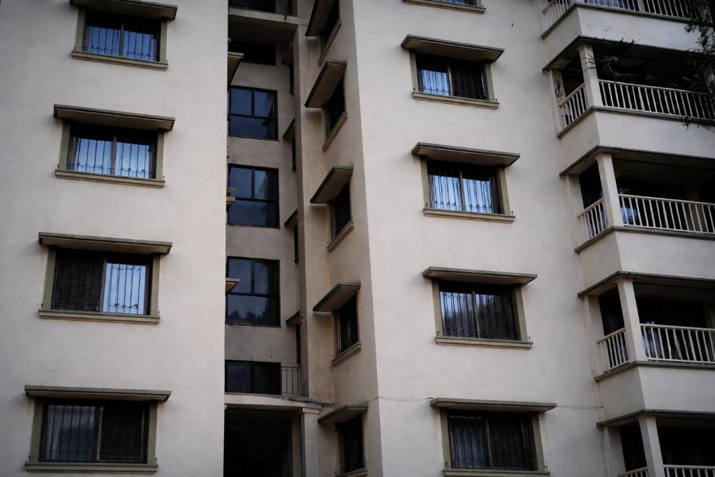 a tall white building with barred windows at Sudama Bhavan in mayapur