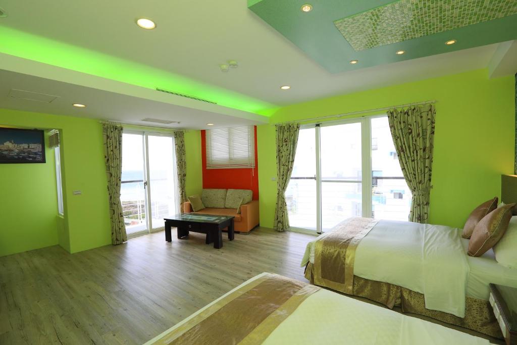 a bedroom with green walls and a bed and a couch at Hang Hai B&amp;B in Eluan