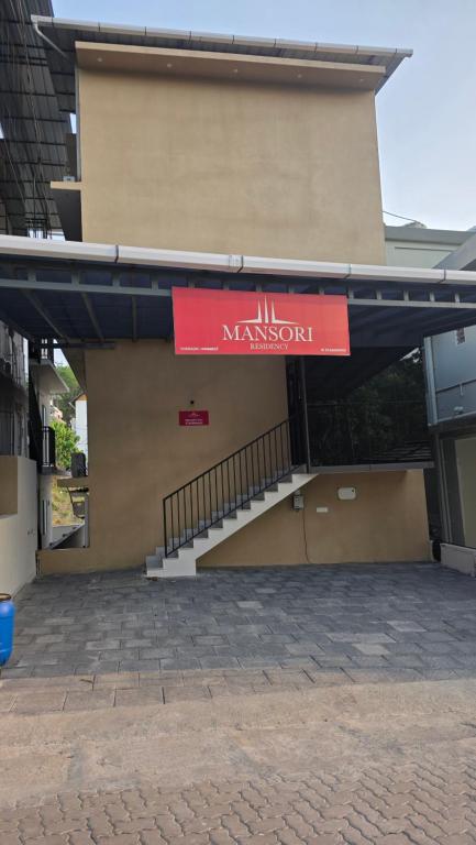 a building with a red sign on the side of it at Mansori Residency in Cochin