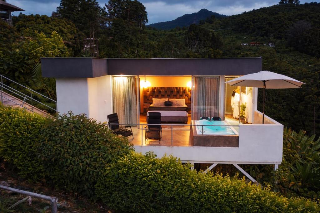 a villa with a bed and an umbrella at Glamping Jalisco in Buenavista