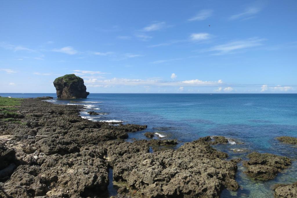 a rocky shore with a large rock in the ocean at Hang Hai B&amp;B in Eluan