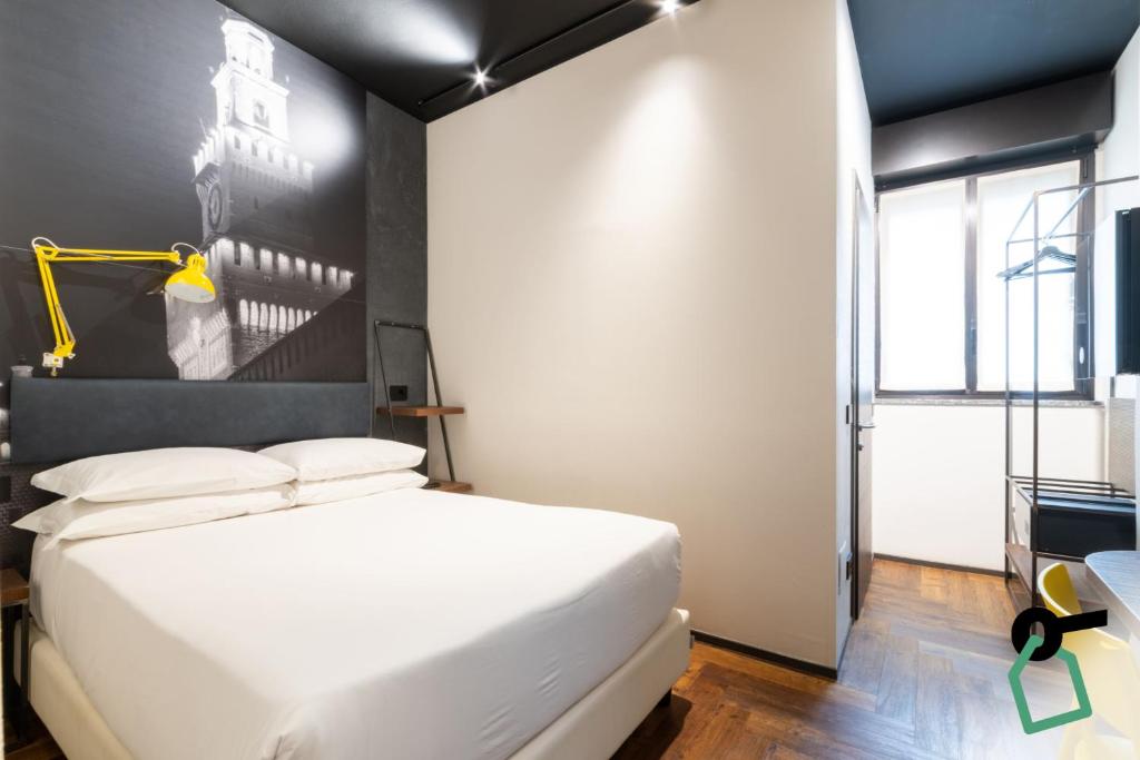 a bedroom with a white bed and a black wall at Hotiday Milano Risorgimento in Milan