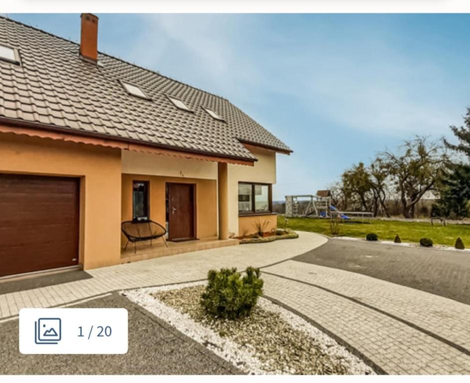 a house with a garage on the side of the road at Dom nad jeziorem in Czerwonki