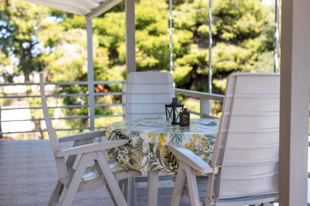 a table and chairs on a porch at Dream Houses Near Athens Airport By SEM in Artemida