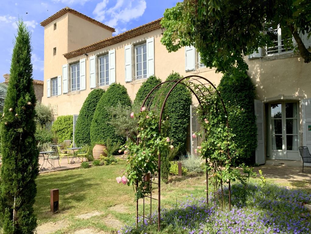 a garden in front of a house with roses at Château De Siran - Hôtel & Spa in Siran