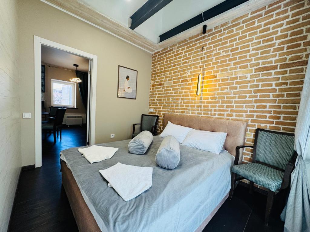 a bedroom with a bed and a brick wall at Apart-Hotel IGORIVSKA in Kyiv