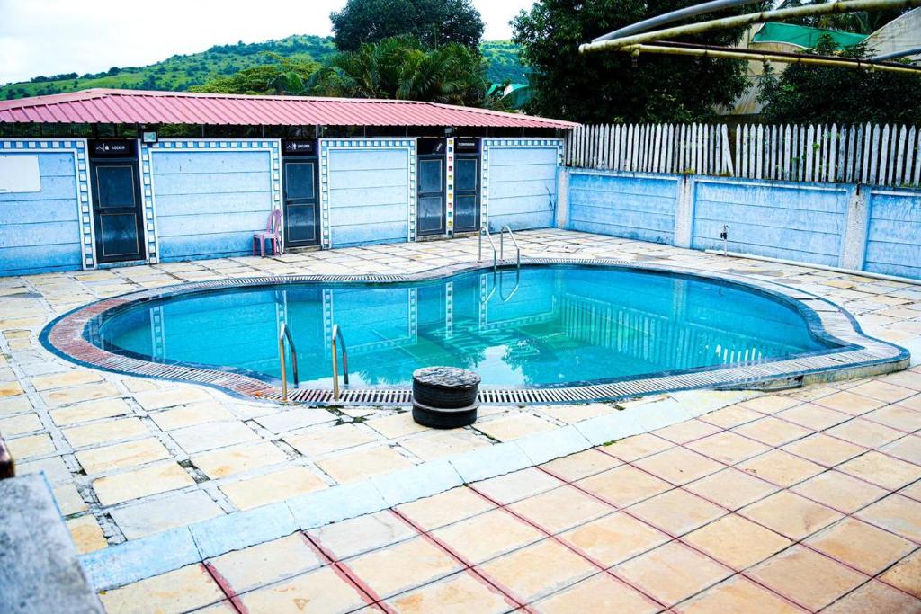 a small swimming pool in a yard with a fence at Harmony Hills Ecostay in Nasrāpur