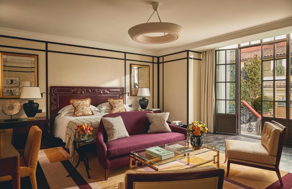 a bedroom with a bed and a purple couch at Rocco Forte The Carlton in Milan