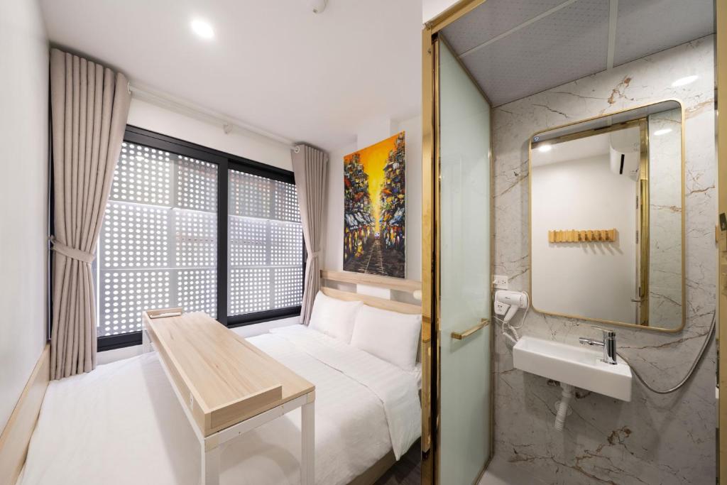 a hotel room with a bed and a sink at 2Re Hidden Hostel 58 Hàng Bạc in Hanoi