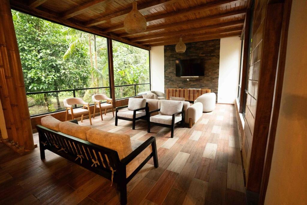 a living room filled with furniture and a large window at Boana Explora Pachijal in Pedro Vicente Maldonado