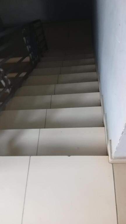 a close up of a staircase with white tile floors at Johannys'co in Abidjan