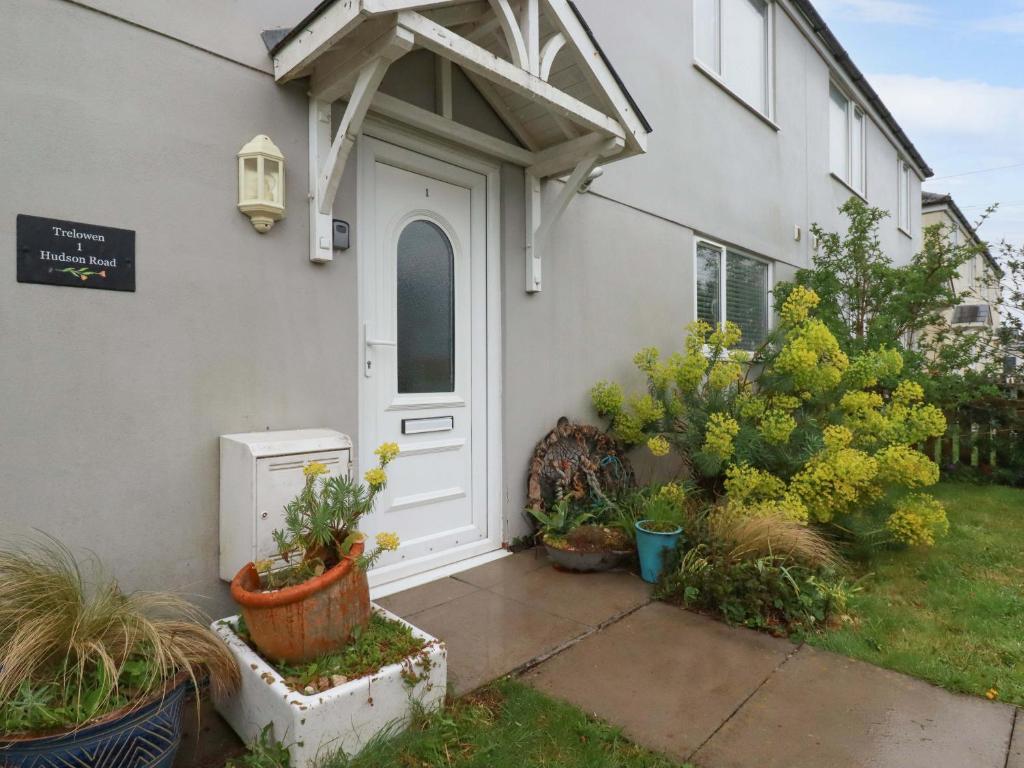 a white door of a house with potted plants at Trelowen in Wadebridge