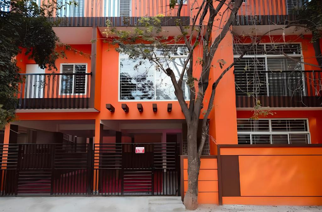 an orange building with a tree in front of it at The Prime Residences of Samuels Comfort Homes in Bangalore