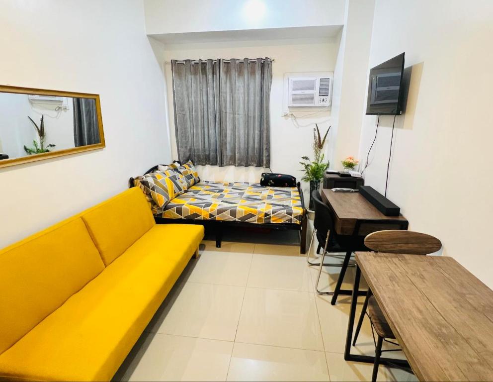 a living room with a yellow couch and a table at Tower1 Smdc green2 Dasmarinas in Dasmariñas