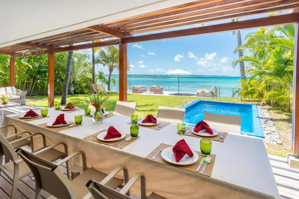 a dining table with a view of the ocean at Ruby in Post of Flacq
