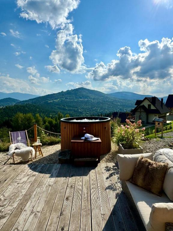 a wooden deck with a hot tub on top of a mountain at Ovis Homes I Gorąca balia - Widok na góry - 8 osób - Komfortowy domek in Zawoja