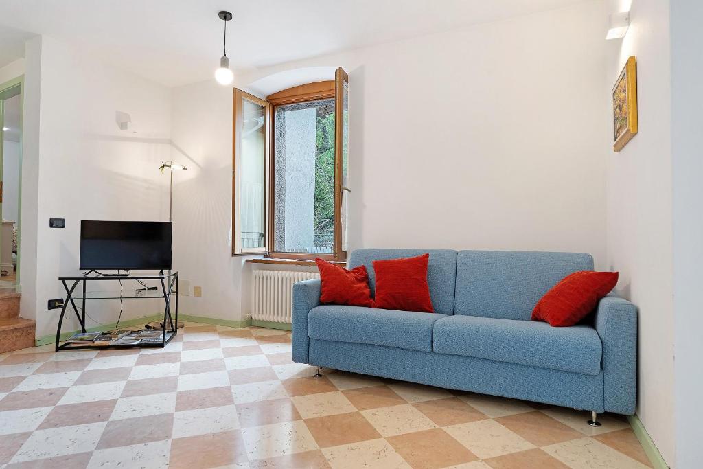 a blue couch in a living room with red pillows at Vallelaghi Escape in Terlago