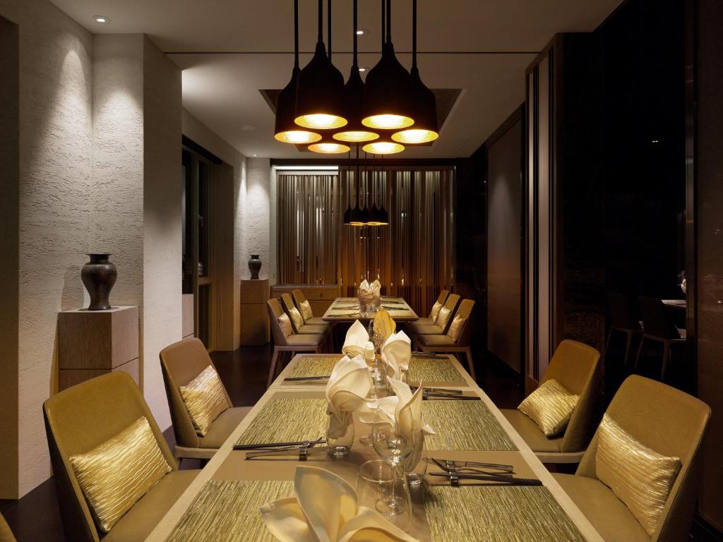 a dining room with a long table and chairs at Gloria Manor in Kenting