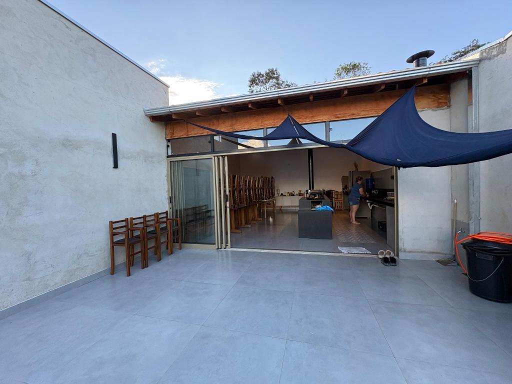 a patio with a blue tent on the side of a building at Recanto Gil Viana in Pouso Alegre