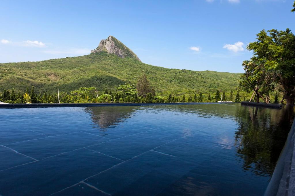 a swimming pool with a mountain in the background at Gloria Manor in Kenting