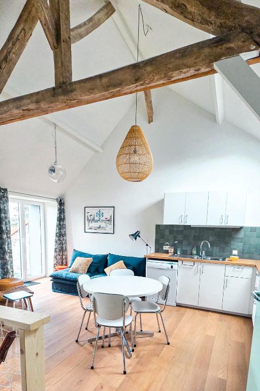 a kitchen and living room with a table and chairs at Cottage des Cerisiers in Lens