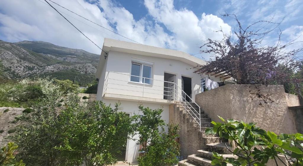 a white house with stairs leading up to it at Apartmans White perl in Sutomore