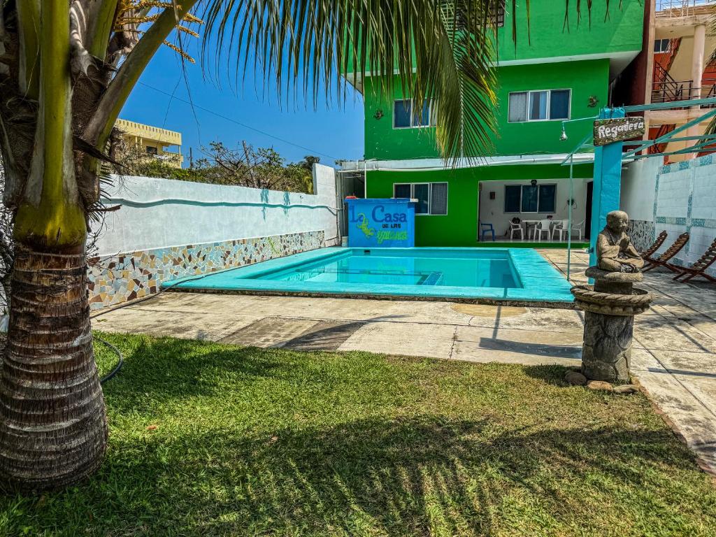 a swimming pool in front of a building with a palm tree at Casa de las Iguanas Tecolutla in Tecolutla