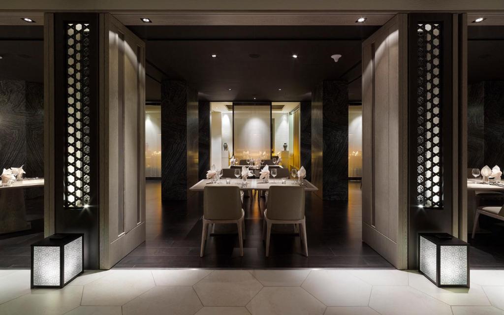 a dining room with a table and chairs and a mirror at Gloria Manor in Kenting
