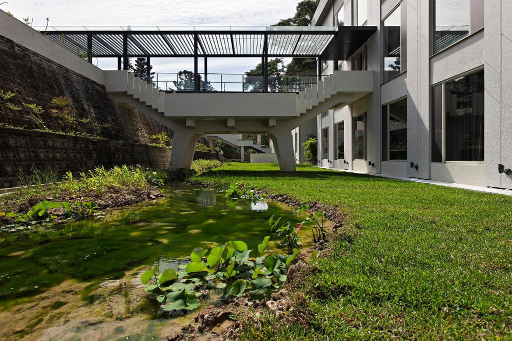 a house with a pond in front of a building at Gloria Manor in Kenting
