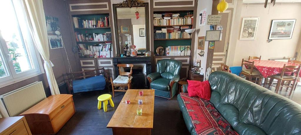 a living room with a green couch and a table at Maison de ville in Rouen