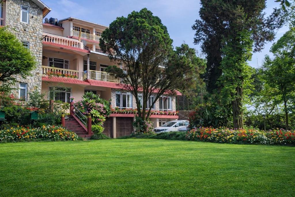 a large building with a lawn in front of it at Shikher Guest House in Kalimpong