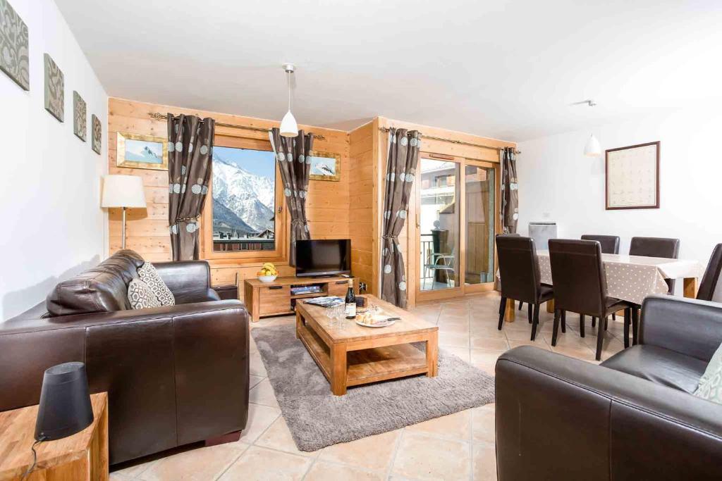 a living room with a couch and a table at Les Sonnailles Apartment - Chamonix All Year in Chamonix