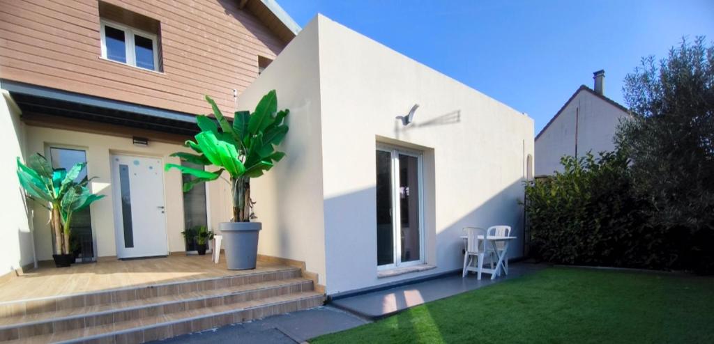 a house with a plant in the front yard at Le Cocon de Marine in Triel-sur-Seine
