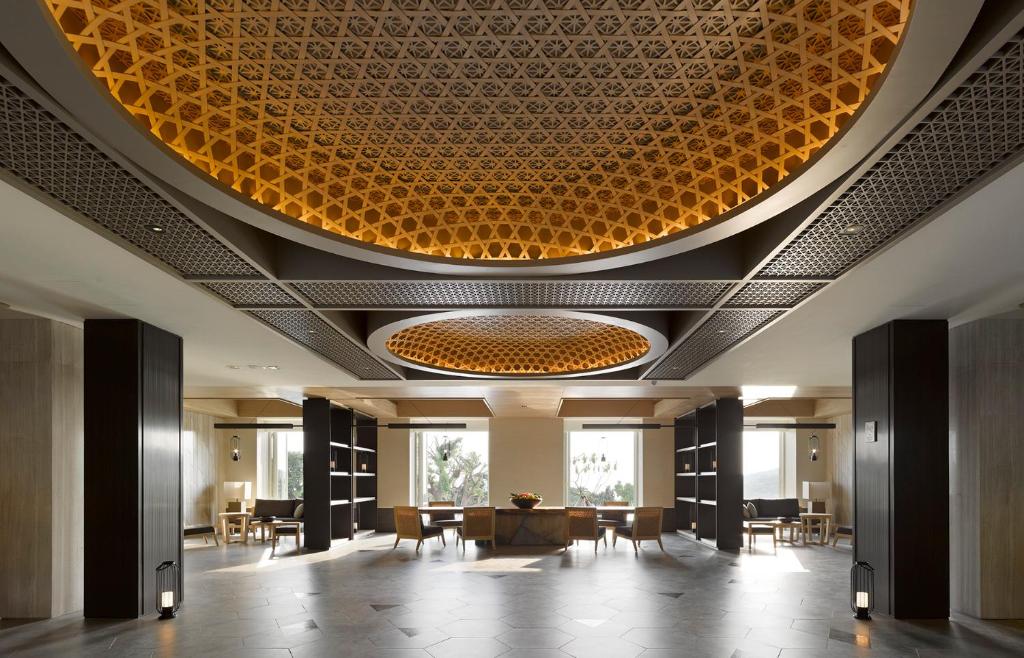 a lobby with a large circular ceiling with tables and chairs at Gloria Manor in Kenting