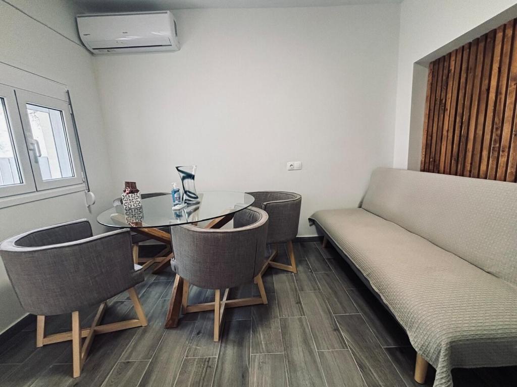 a room with a table and chairs and a couch at Nára house 3 in Spata