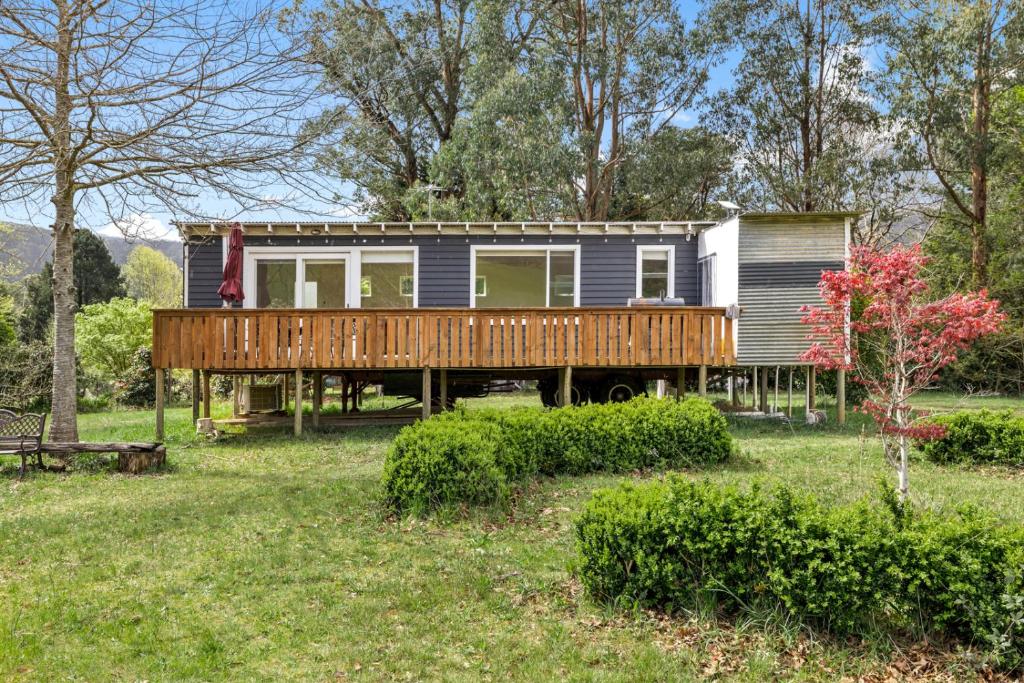 a small house with a deck and a yard at Tiny house at Gilderoy Valley Views in Yarra Junction