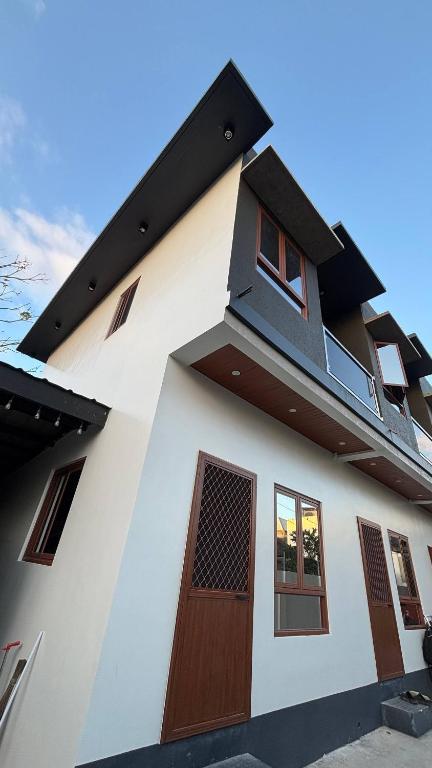 a white building with a brown door and windows at R&G Residences in Legazpi