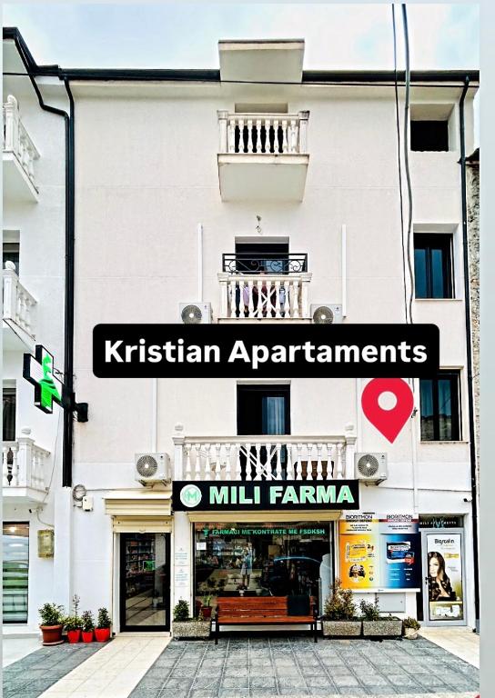 a building with a sign that reads kristian apartments mill farmania at Kristian apartments in Berat